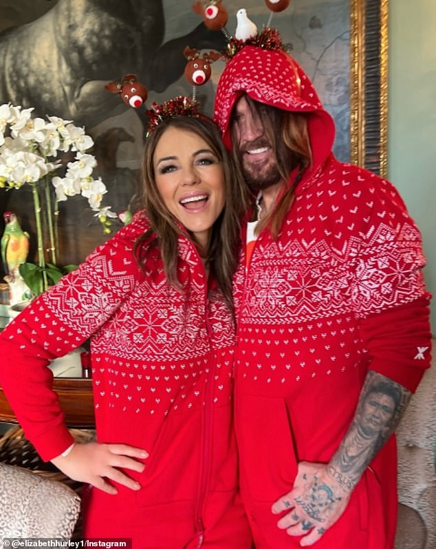 Elizabeth Hurley and Billy Ray Cyrus got into the holiday spirit - and matching onesies - as they spent their first Christmas together