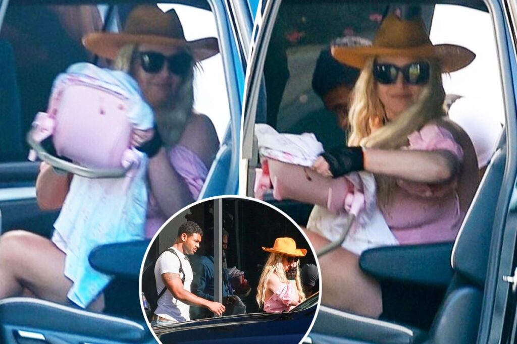 Britney Spears bizarrely totes toy baby carrier as she returns from Cabo with ripped fitness influencer