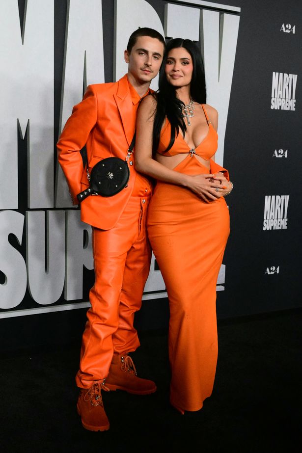 Timothee and kylie in orange posing on red carpet of film