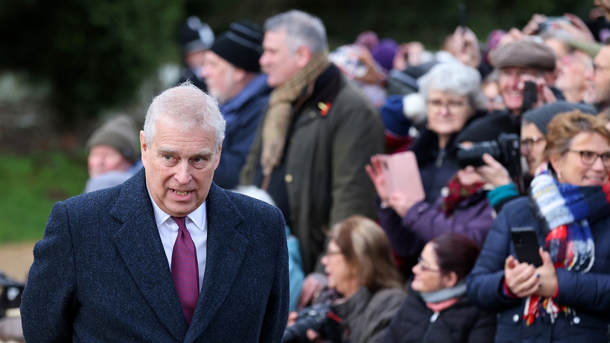 Ex-Prince Andrew looking away from a crowd outside taking photos.