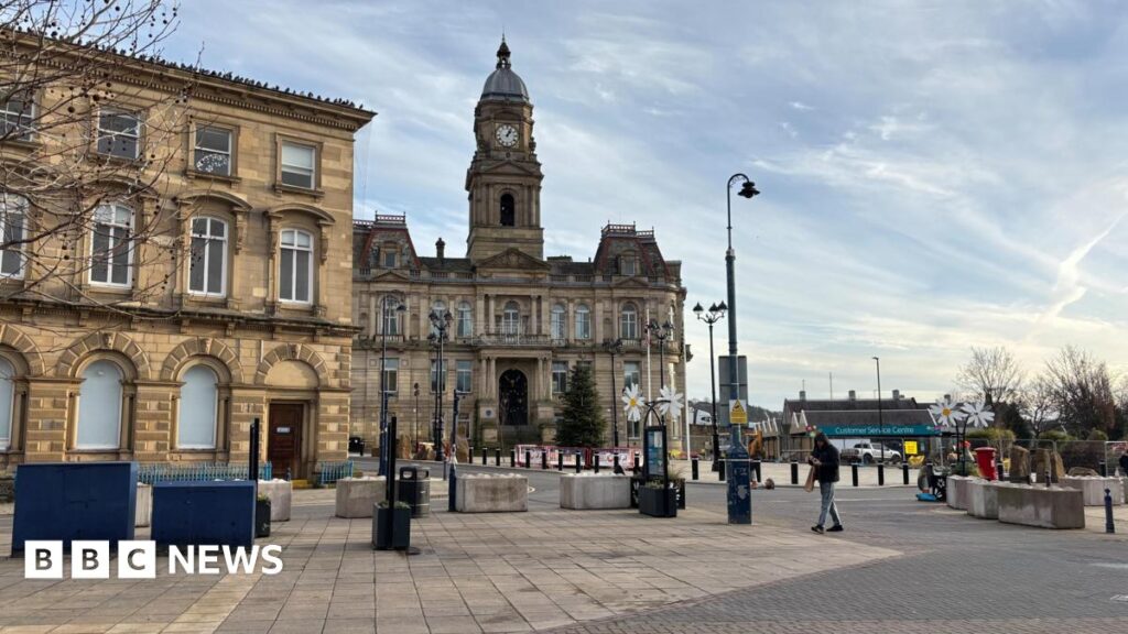 Dewsbury residents on their town and what changes they want to see An artist's impression of a new park in Dewsbury, there is a large paved area with flower beds at each side and a grassed area, with people milling about and some fountains on the left.