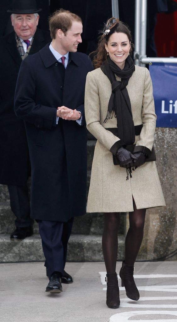 Kate in neutral coat dress and william in suit smiling outside