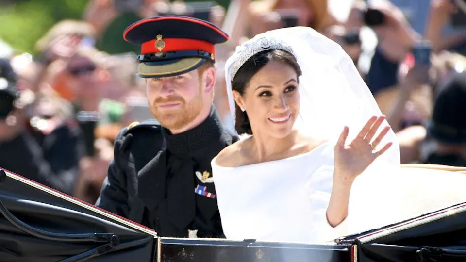 Prince Harry, Duke of Sussex and Meghan, Duchess of Sussex leave Windsor Castle in the Ascot Landau carriage after getting married at St Georges Chapel on 19 May, 2018. Prince Harry wears military uniform while Meghan Markle wears a white off-the-shoulder dress and veil, held in place by a jewelled tiara.