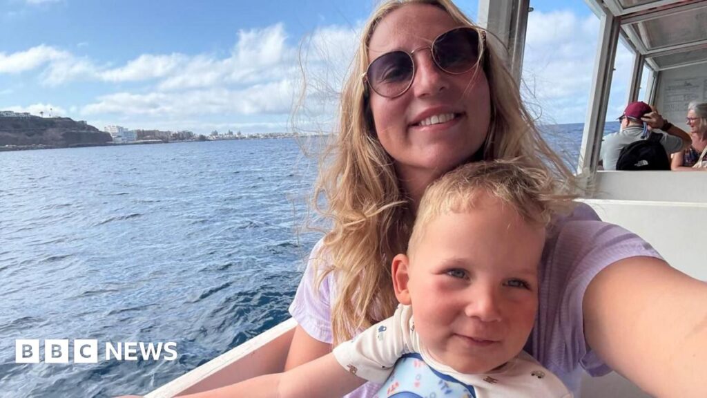 Colchester boy given £1.8m drug has new lease of life Edward stands in a blue, black and grey wetsuit next to a swimming pool with two people in it. He has dark blonde wavy hair.