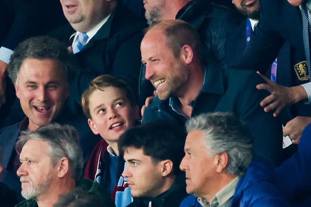 Prince William and Prince George smiling during a football match
