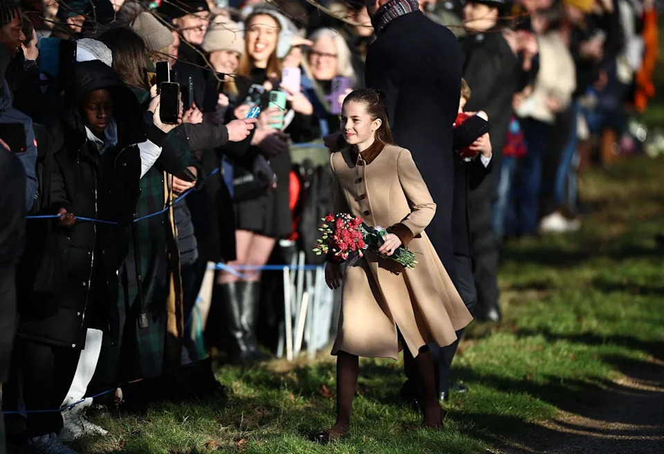 Princess Charlotte clutched a bouquet of flowers in her arms as she greeted crowds in Norfolk (AFP via Getty Images)