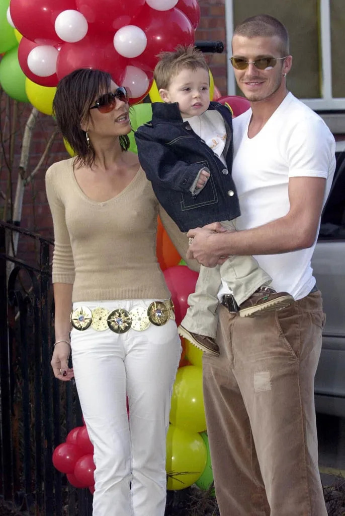 I don't know who these people are, but they are at an outdoor event. The adults are wearing casual clothing, and the child is being held by the man