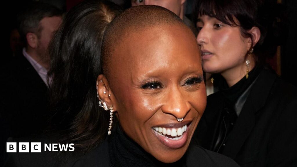 Cynthia Erivo’s journey from nativity play solo to MBE Cynthia Erivo smiling at a Wicked: For Good event, she is wearing several diamond earrings and a diamond nose ring. Her head is shaved.