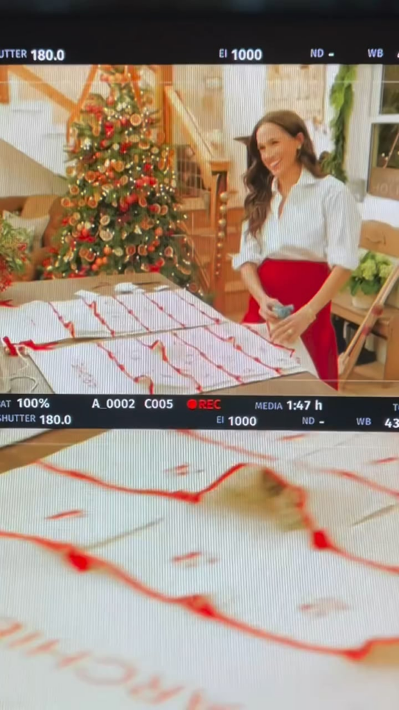 Meghan shares some behind the scenes footage from her Christmas special and shows off her calligraphy skills live