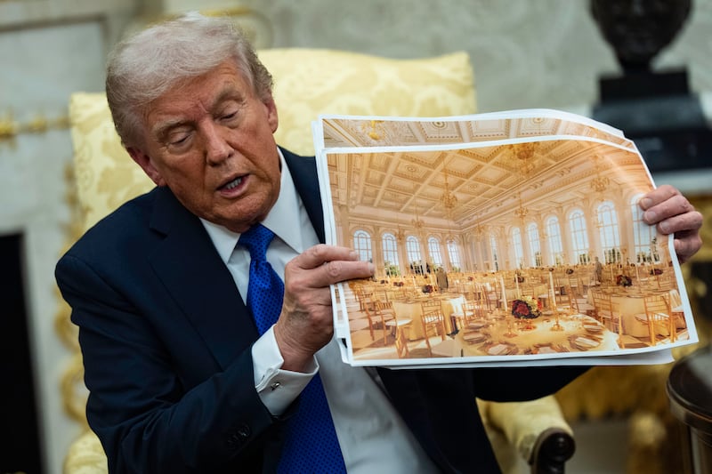 President Donald Trump speaks holding a photos of the new ballroom during a meeting with NATO Secretary General Mark Rutte in the Oval Office of the White House in Washington, DC on October 22, 2025.