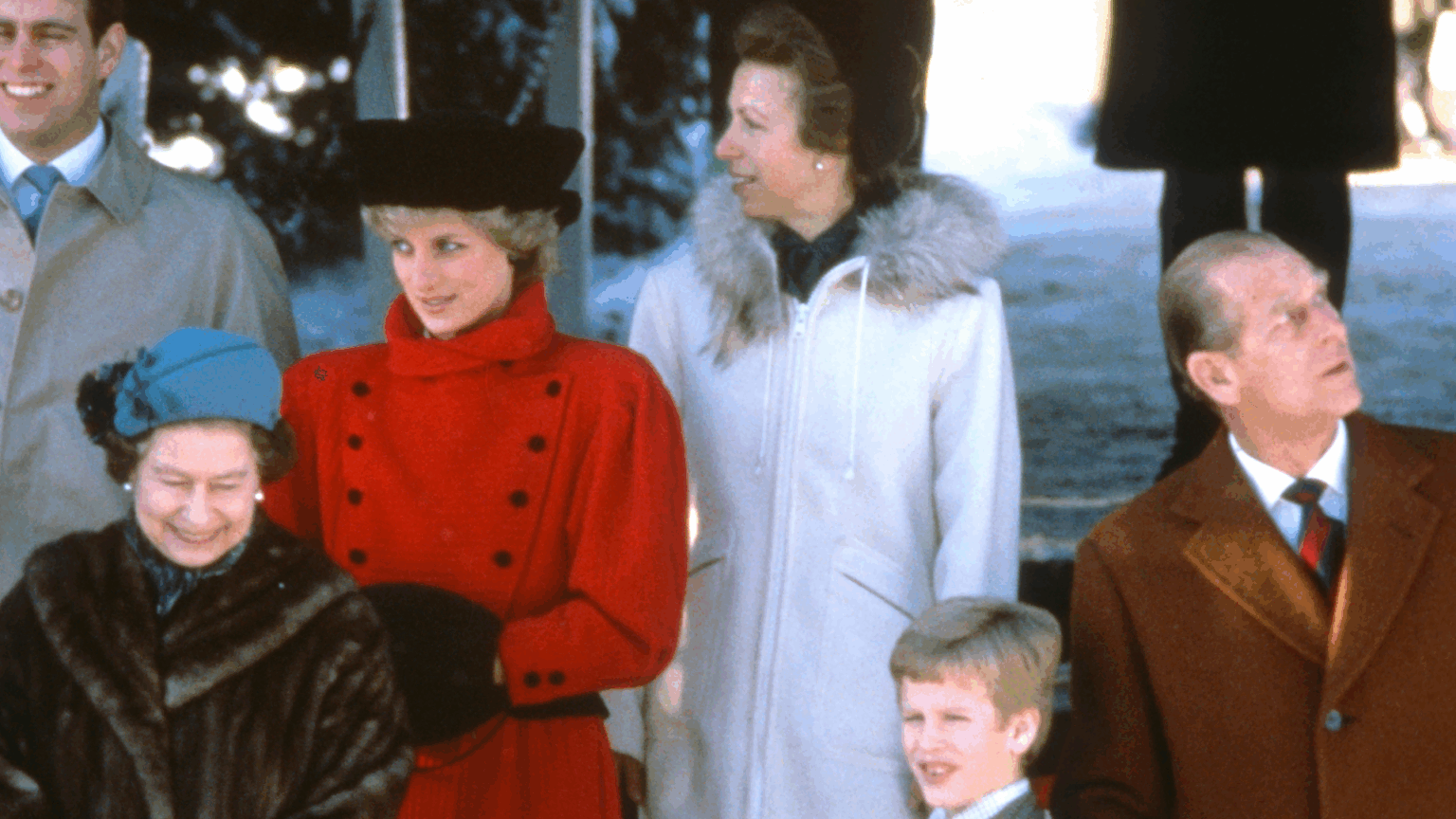Queen Elizabeth in a fur coat, Princess Diana in a red coat, Princess Anne in a white coat and Prince Philip looking up to the side outside church at Christmas