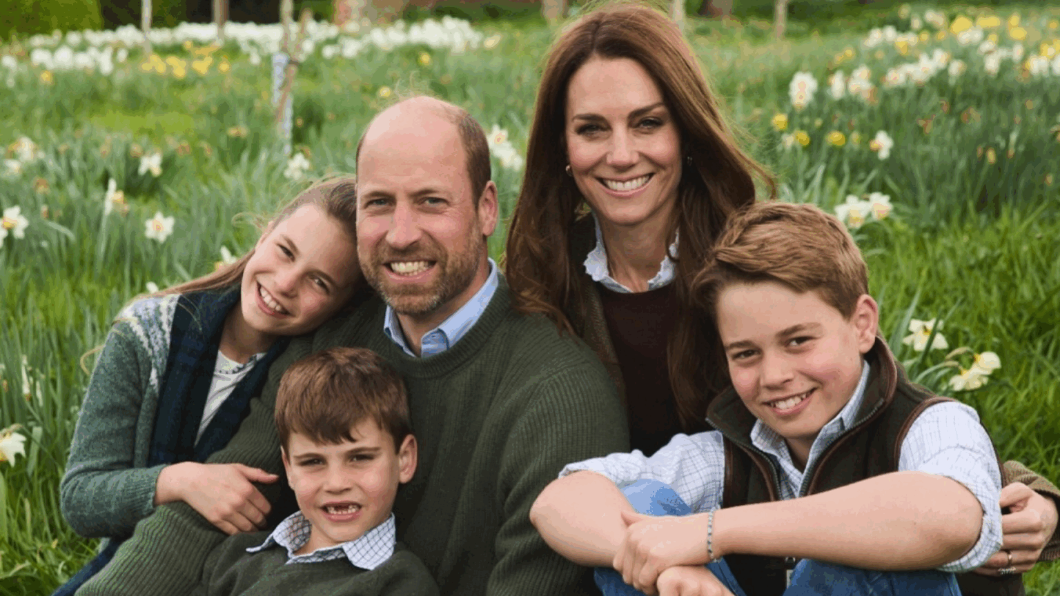 Royal Expert Reveals the Secret Meaning Behind William and Kate’s “Symbolic” Christmas Card Photo Prince William, Princess Kate, Princess Charlotte, Prince Louis and Prince George sitting in a field of flowers