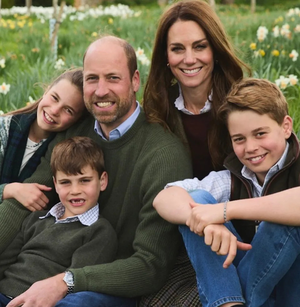  Prince William, Princess Kate, Princess Charlotte, Prince Louis and Prince George sitting in a field of flowers. 