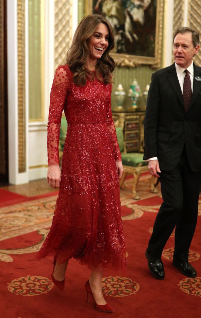 Britain's Catherine, Duchess of Cambridge (L) walks through to the State Room at a reception for heads of State and Government at Buckingham Palace wearing Needle & Thread