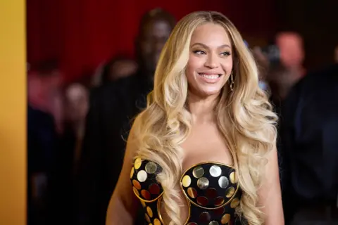 EPA Beyoncé in a gold and black dress