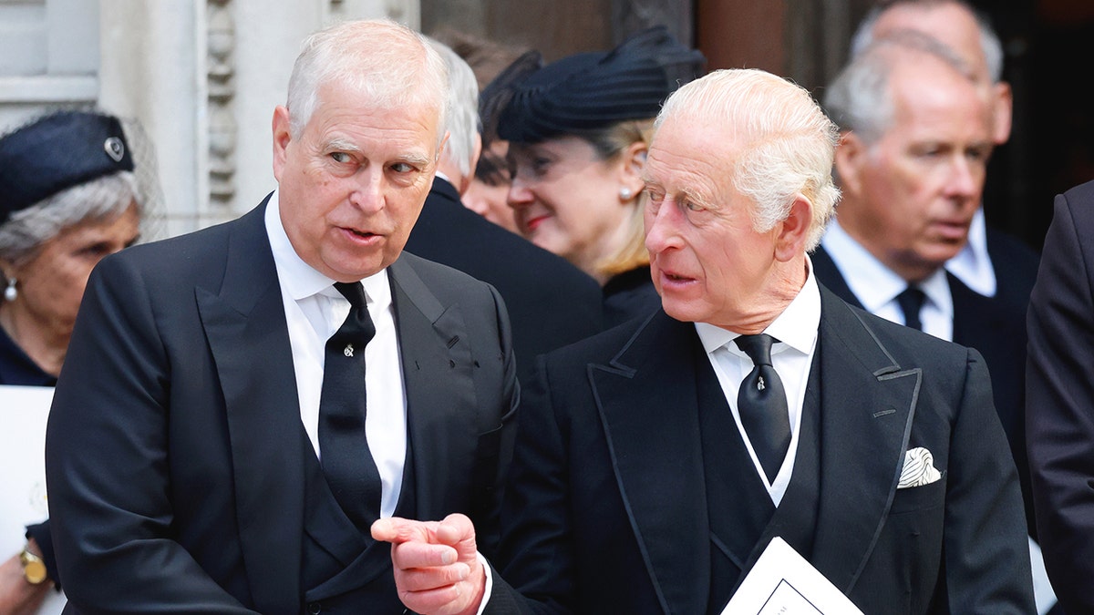 Ex-Prince Andrew and King Charles speaking to each other outside of church looking serious as they both wear matching black suits.
