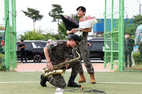 Getty Images RM and V of BTS celebrate their discharge from the South Korean army after completing military service