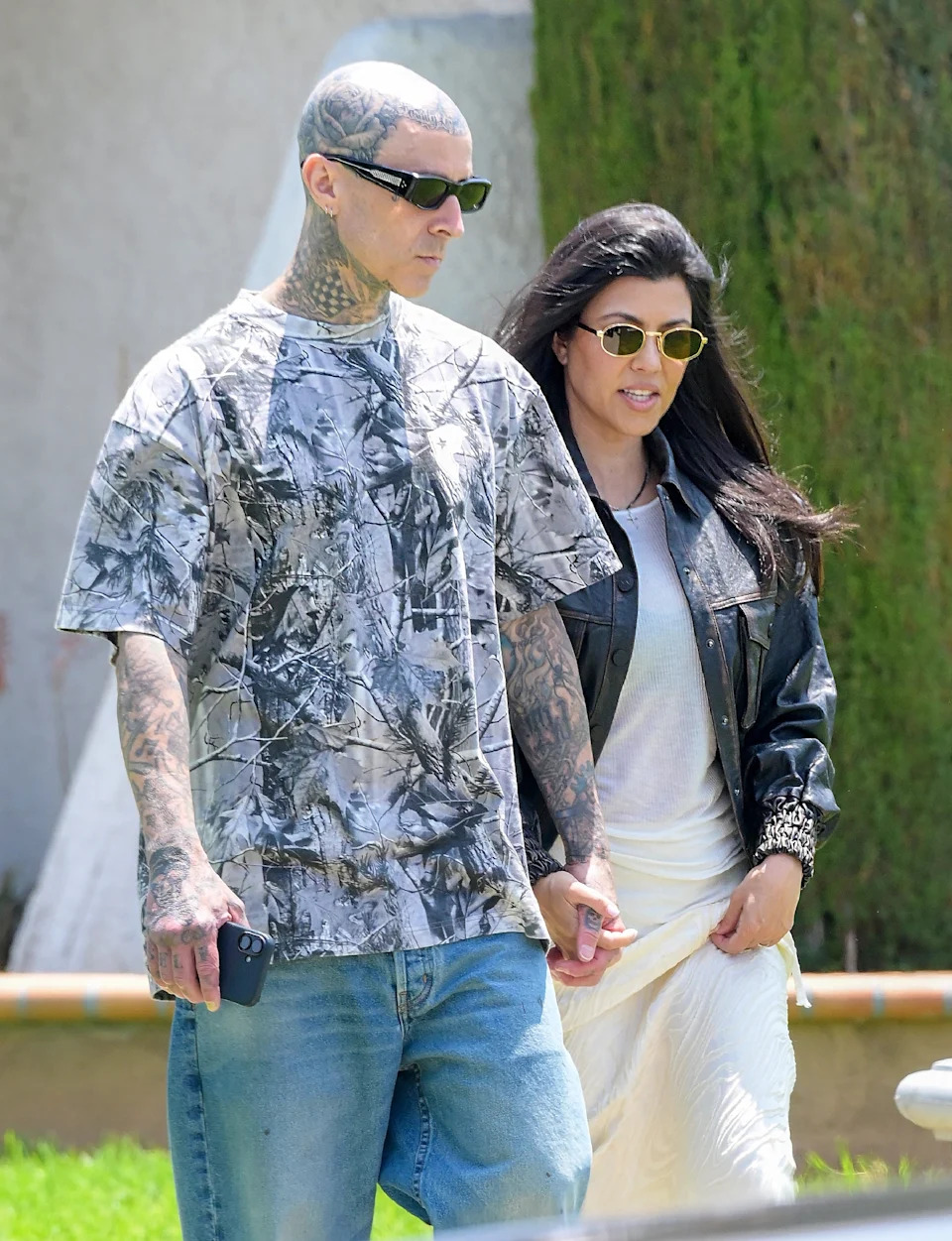 Travis Barker and Kourtney walking outdoors