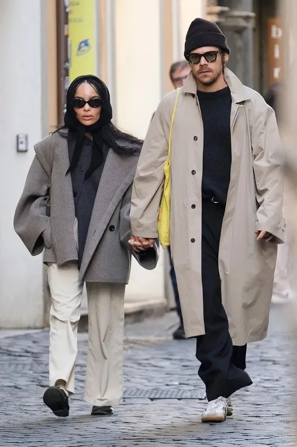 Zoë Kravitz wearing layered gray wool coats with wide-leg trousers and sunglasses