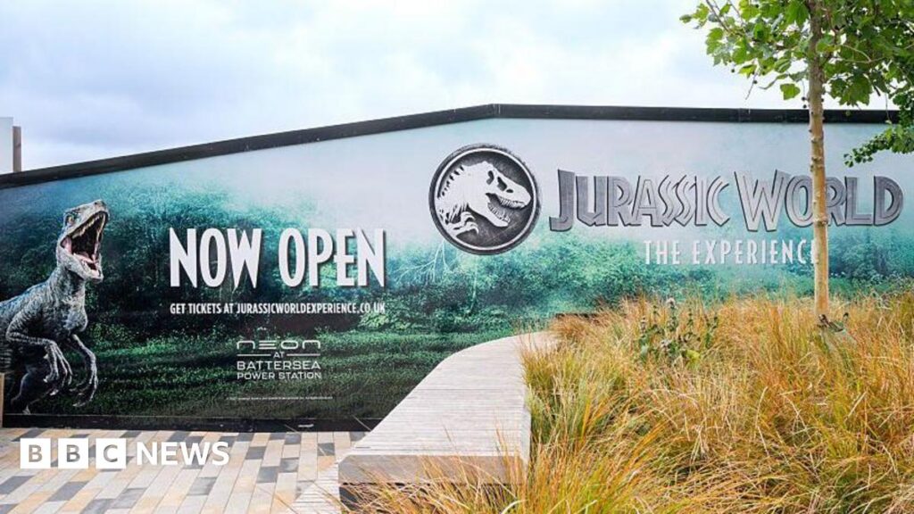 Jurassic World event apologises after ticket holders turned away The exterior of the exhibition. There are billboards advertising the Jurassic World experience with pictures of dinosaurs.
