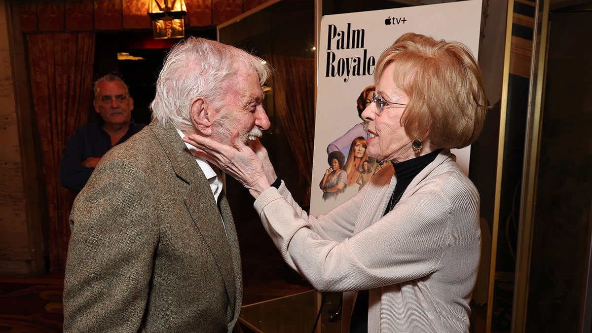 Carol Burnett holding onto the smiling face of Dick Van Dyke.