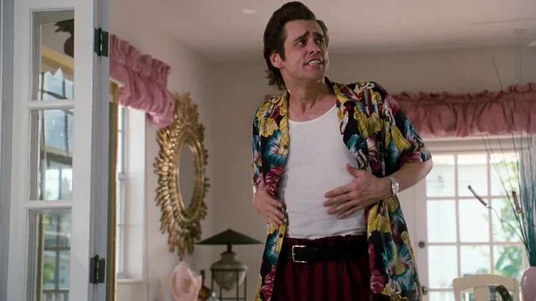 Jim Carrey's Ace Ventura stands in a living room in Ace Ventura Pet Detective.jpg