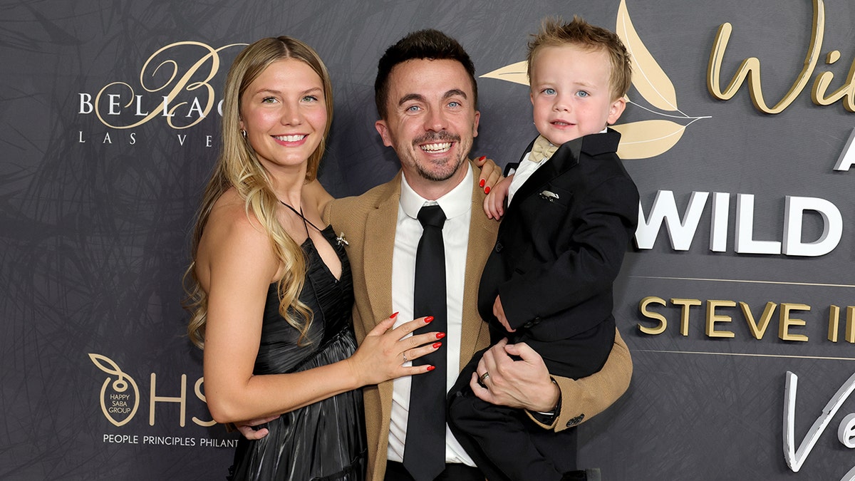 The Muniz family smiling on a red carpet.