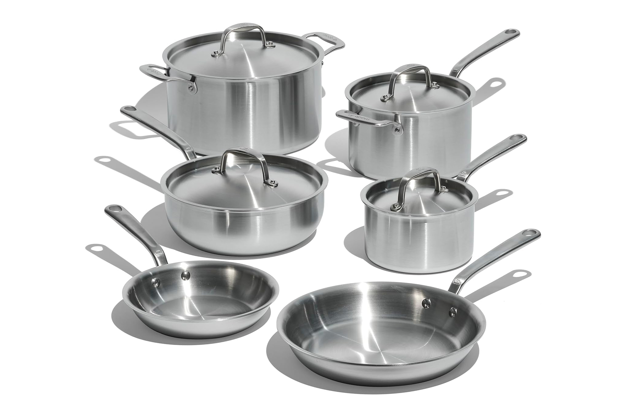 A set of Made In brand stainless steel cookware, including pots with lids and frying pans.