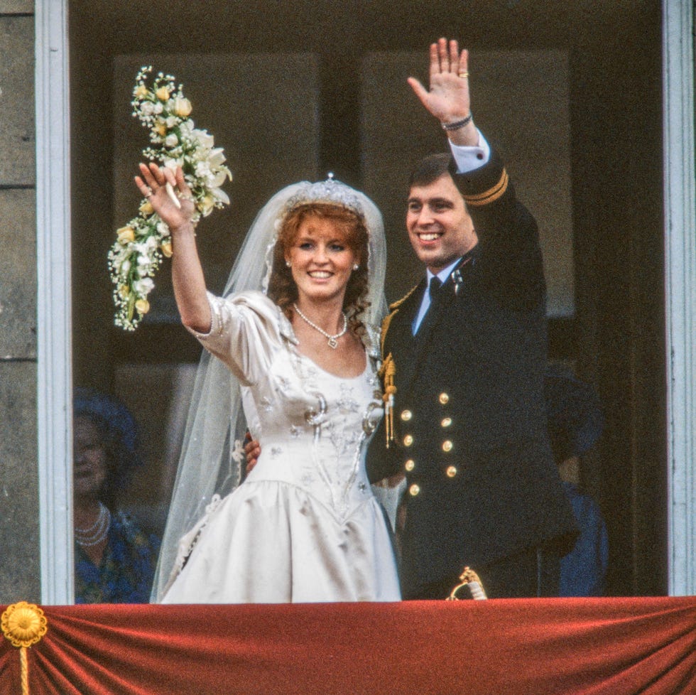 view of just married couple sarah, duchess of york, and prince andrew, duke of york, as they wave from the balcony of buckingham palace, london, england, july 23, 1986. (photo by derek hudson/getty images)