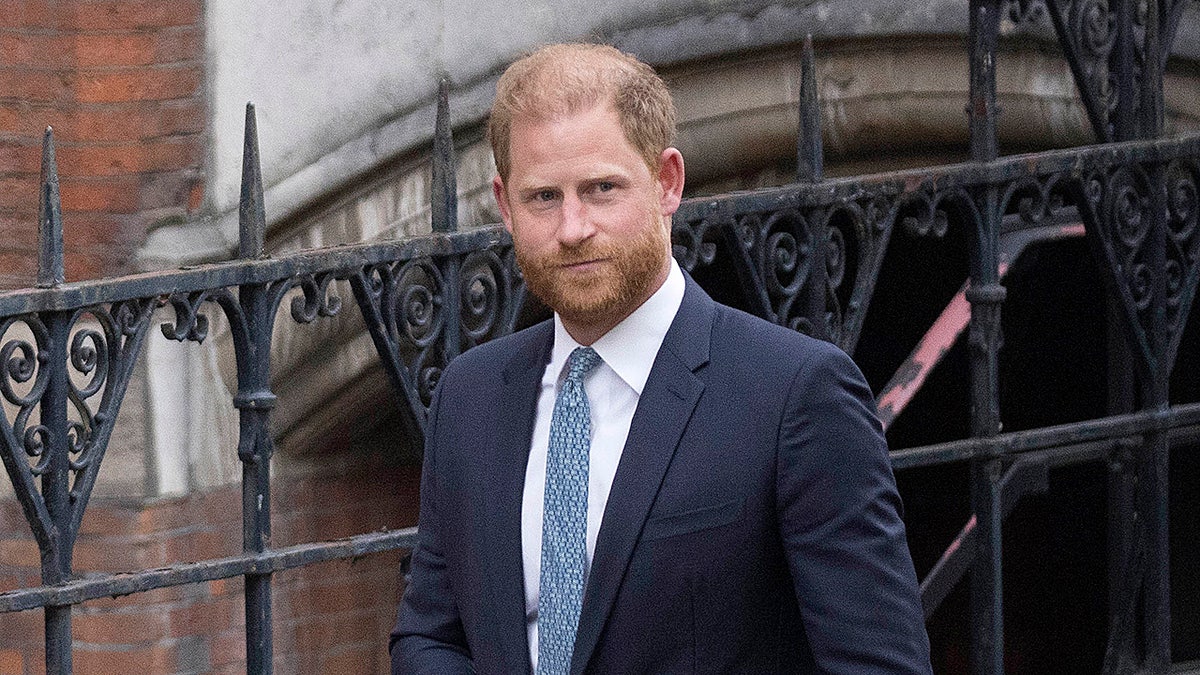 Prince Harry in blue suit outside royal court