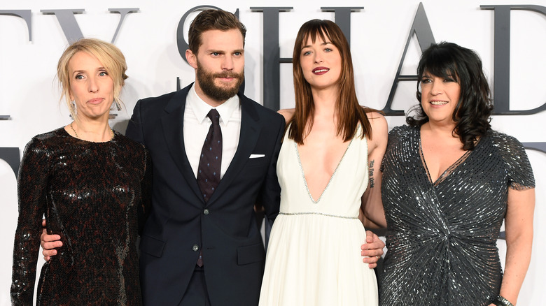 Sam Taylor-Johnson, Jamie Dornan, Dakota Johnson, and author E.L. James smiling at the UK Premiere of 