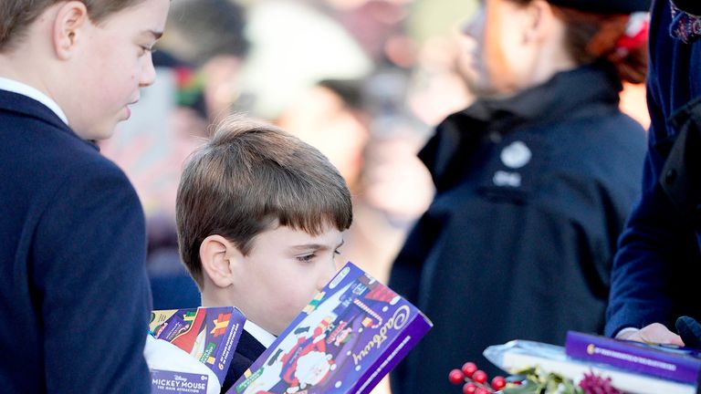 Prince George and Prince Louis hold gifts from members of the public. Pic: PA