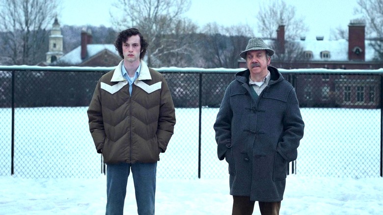 Dominic Sessa and Paul Giamatti as Angus and Paul standing outside in The Holdovers
