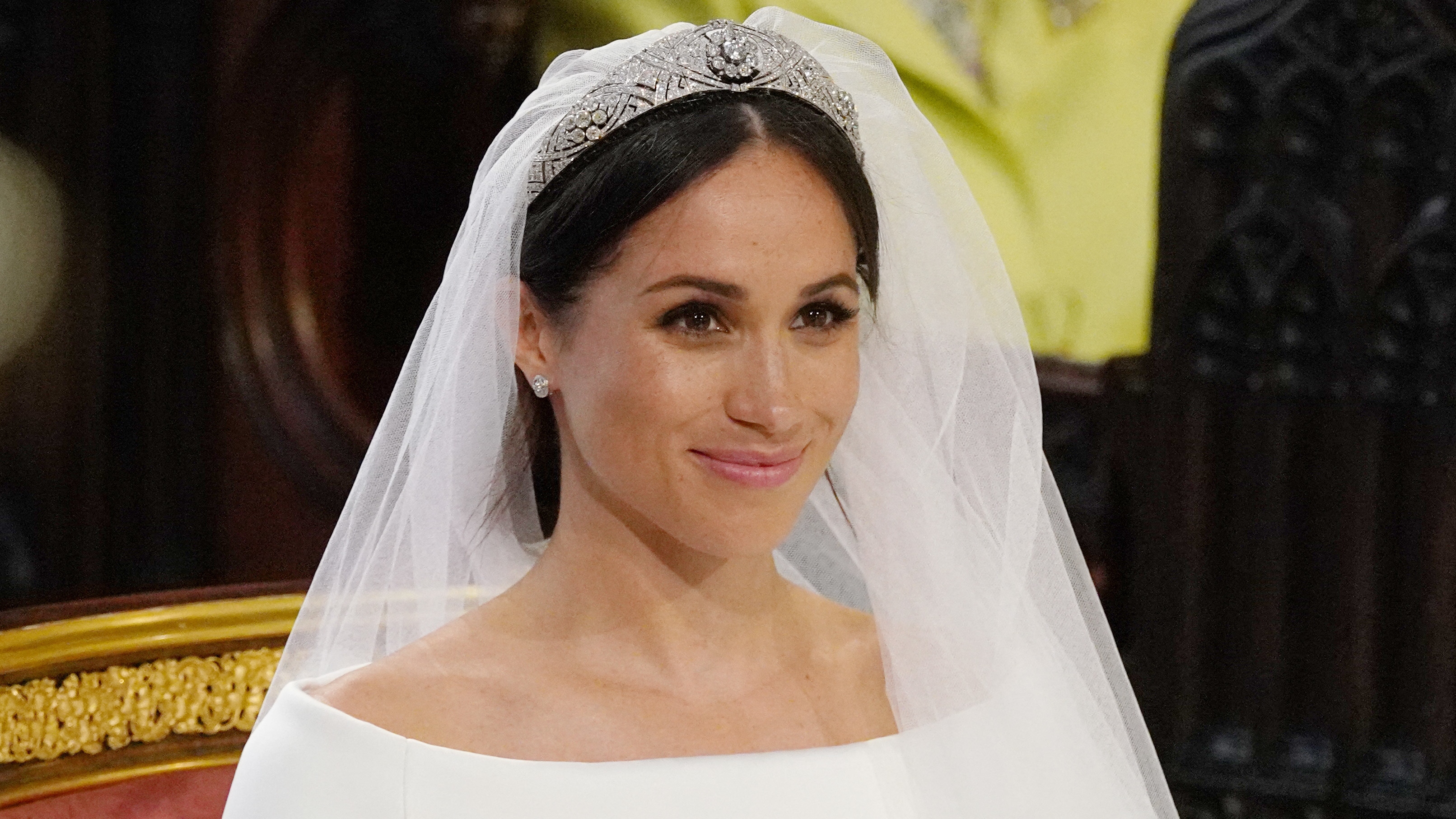 Meghan Markle sits at the High Altar wearing a tiara at her wedding ceremony in St George's Chapel, Windsor Castle