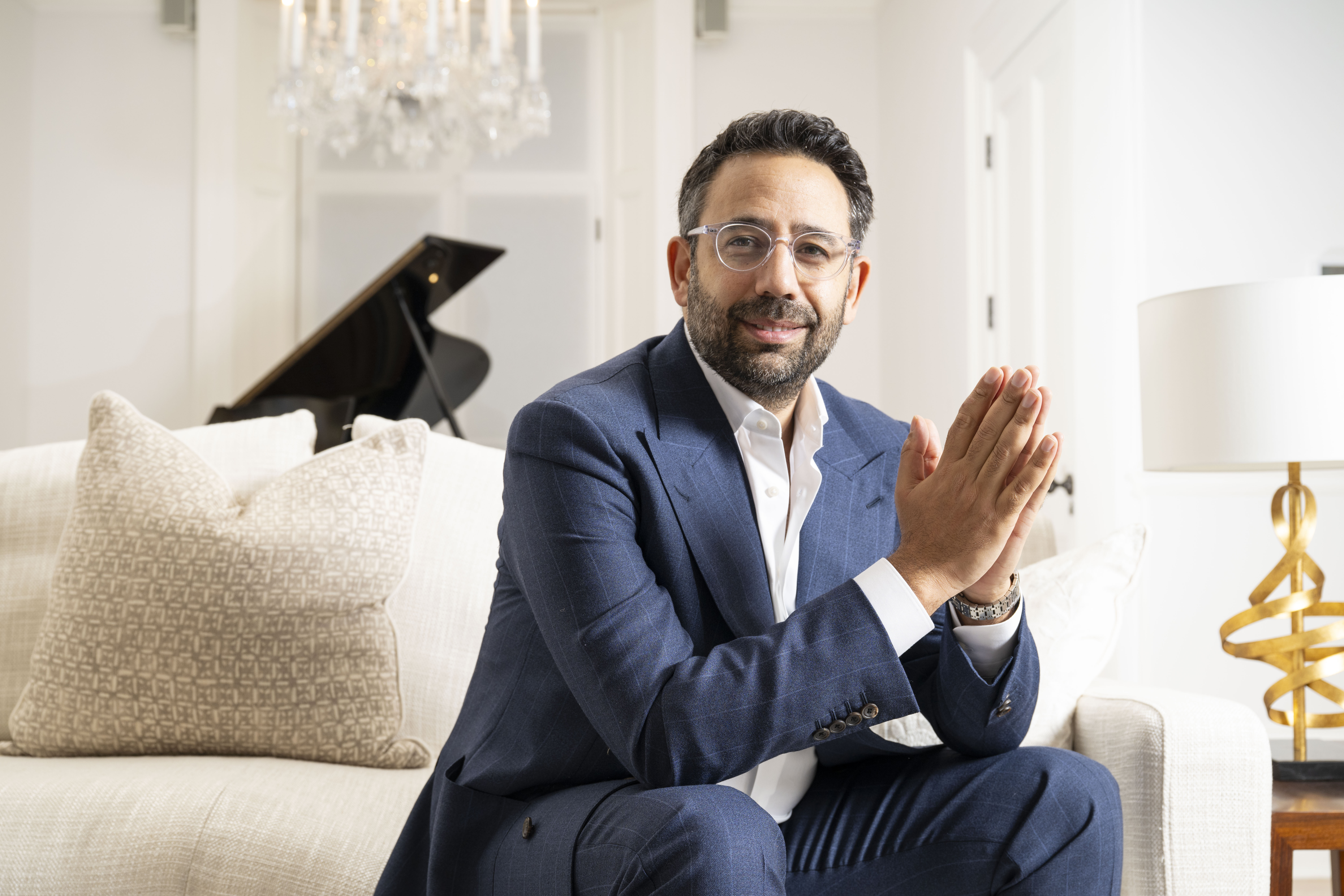 Daniel Daggers, a high-end home seller, sits on a sofa in a London home he is selling.