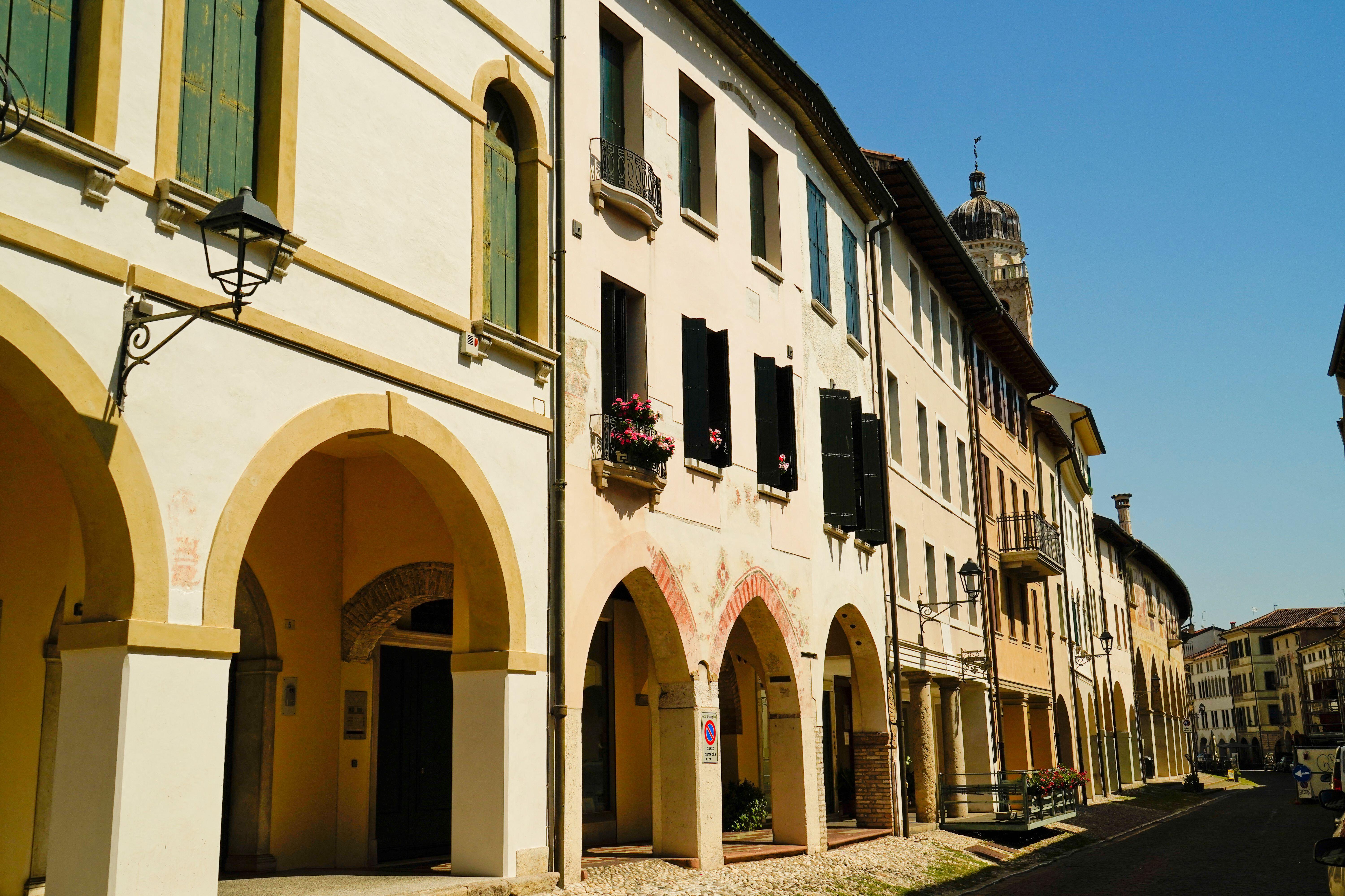 The historic center of Conegliano Veneto in the province of Treviso, Italy, with arches, buildings, and a bell tower.