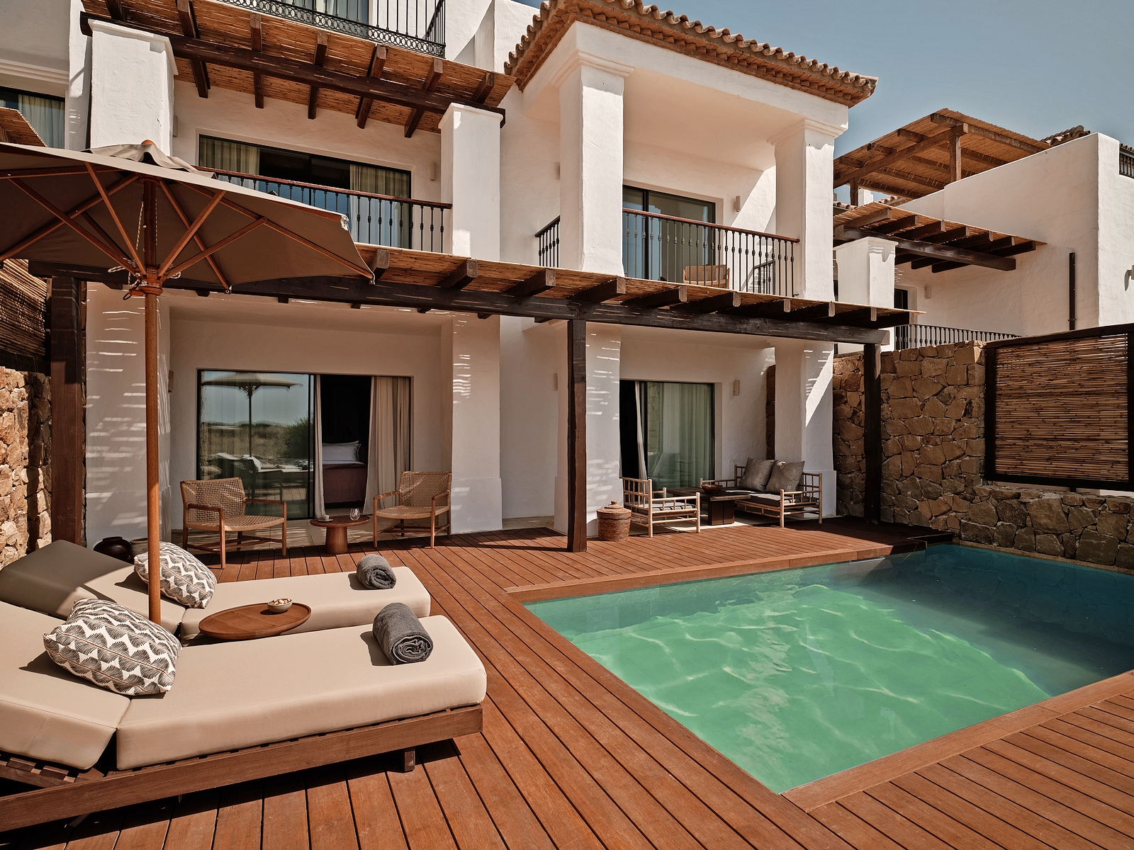Deluxe suite at OKU Andalusia with a private pool and sun loungers on a wooden deck.