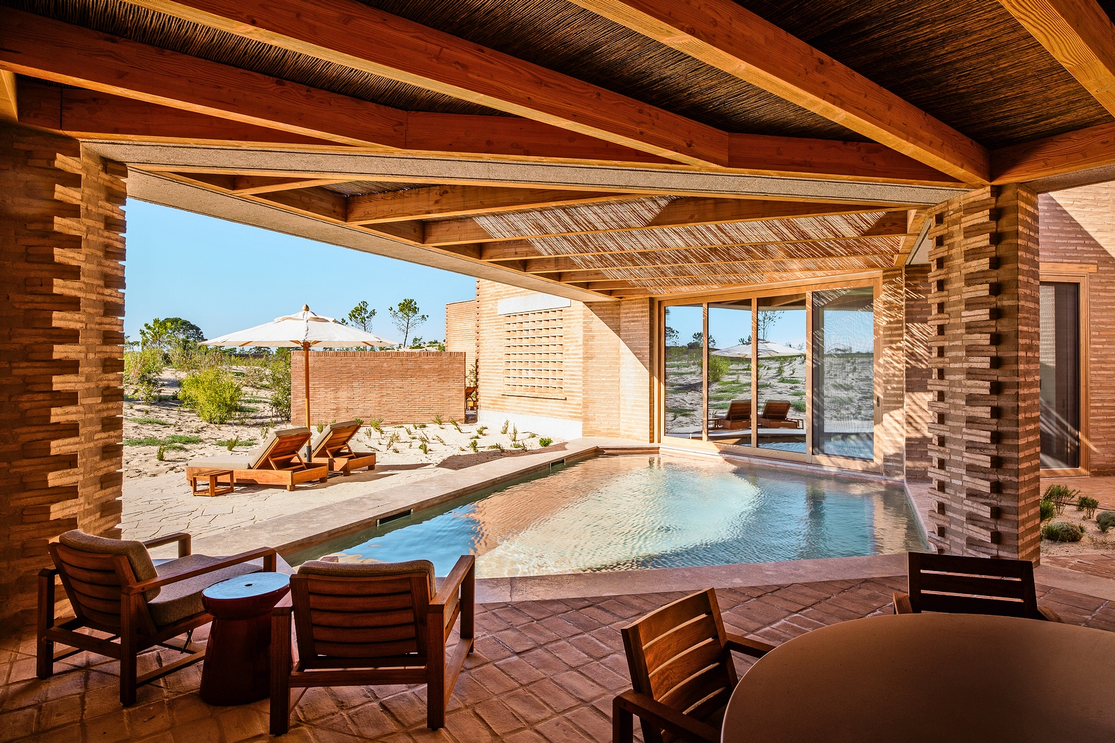 View of a swimming pool and patio area at Na Praia, Praia da Comporta, Portugal.