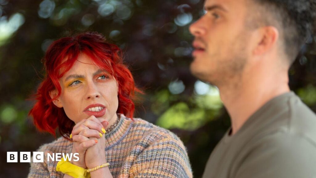 Traitors star Jessie ‘on a high’ after raising stammer awareness Traitors contestant Jessie Stride is seen chatting to fellow faithful Matthew. Jessie has bright red hair, yellow and orange eyeshadow and is wearing a rainbow jumper. The background has trees.