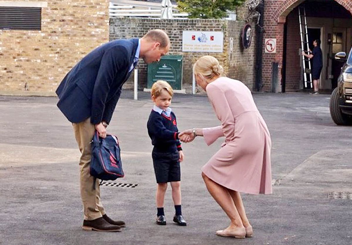  Handout photo issued by Kensington Palace of Helen Haslem, head of the lower school greeting Prince George and the Duke of Cambridge at Thomas's Battersea in London, as he starts his first day of school.