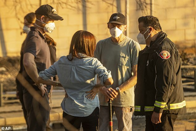 Prince Harry and Meghan were photographed alongside Pasadena Mayor Victor Gordo (right) days after the blaze broke out