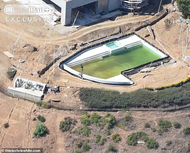 Once a crystal clear blue, the pool water has turned algae-green as construction work continues around it