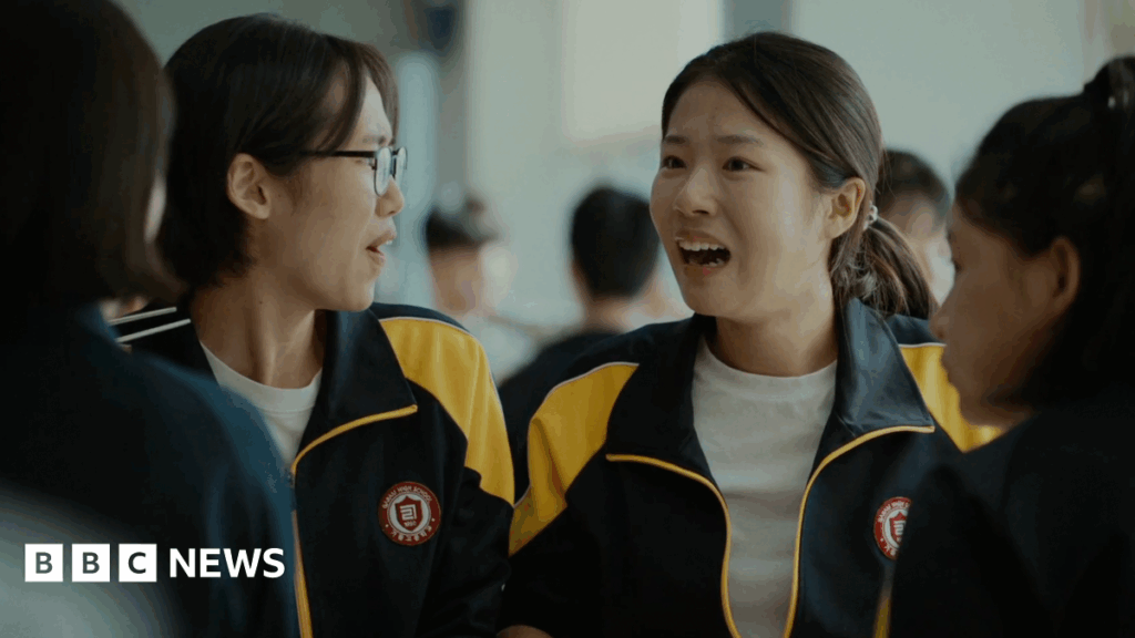 The World of Love: South Korea’s ‘movie of the year’ about teen trauma Four high school girls sit together in a cafeteria. They are wearing matching black-and-yellow athletic-school school jackets. Joo-in's friend, left, is turned slightly to the side wearing glasses, while Joo-in faces forward with her mouth open mid-expression