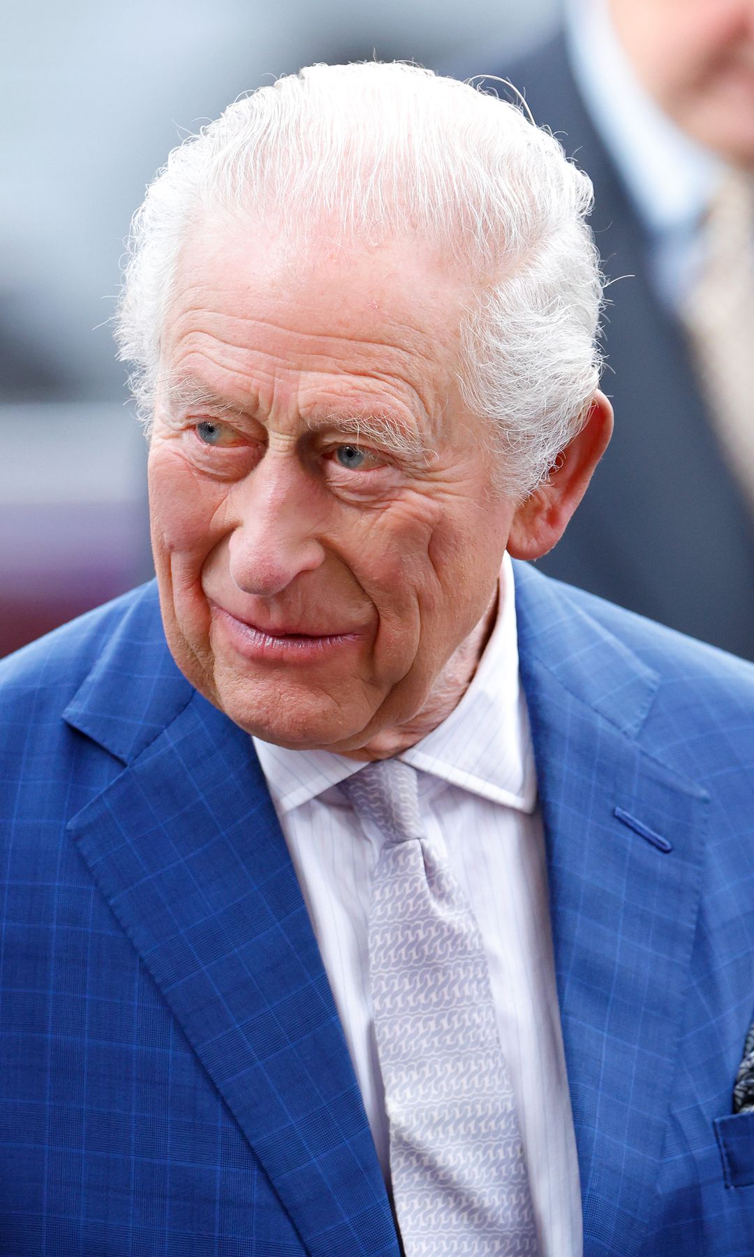King Charles smiling in blue suit