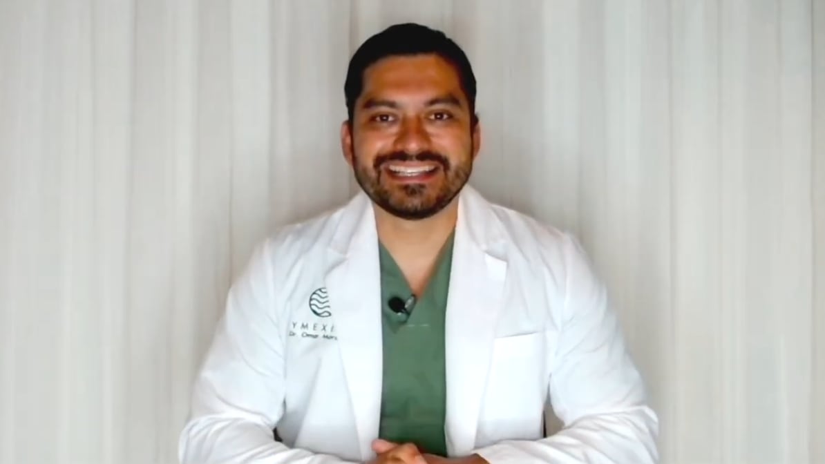 A smiling man wearing a lab coat.