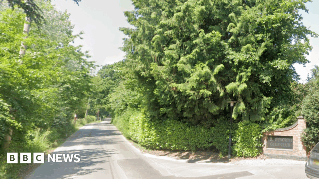 A stretch of Crewe Lane in Kenilworth is flanked by green trees and bushes. On the right hand side is a bricked entrance to Kenilworth Golf Club.