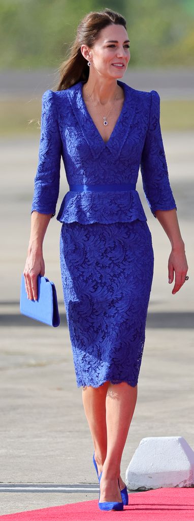 Kate in a cobalt pencil skirt and top on airport runway
