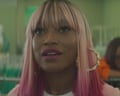 woman with pink hair looks ahead