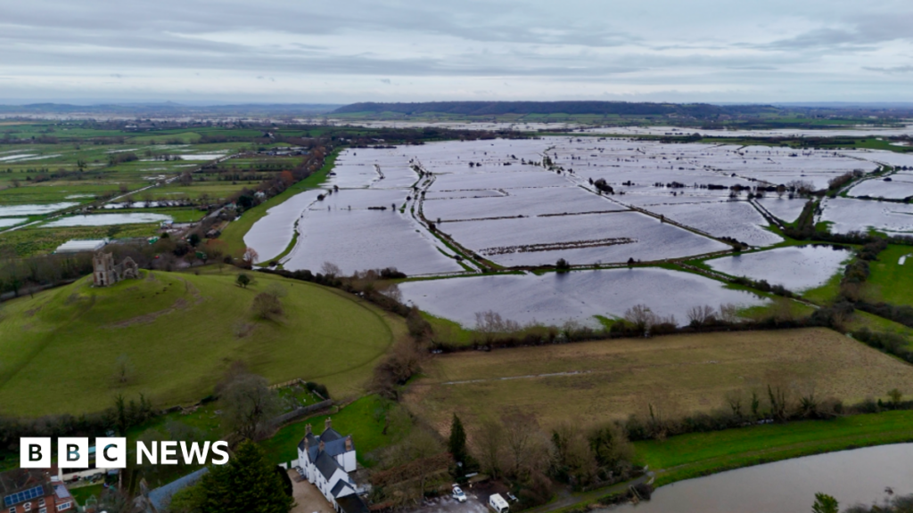 A drone shot showing flooded fields on the Somerset lewvels with a small village in the foreground
