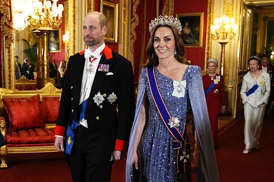 Prince William wearing a black tux and Princess Kate wearing a blue sequined gown and tiara